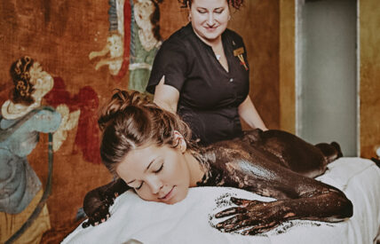 A person receiving a full-body spa treatment at 100 fountain spa