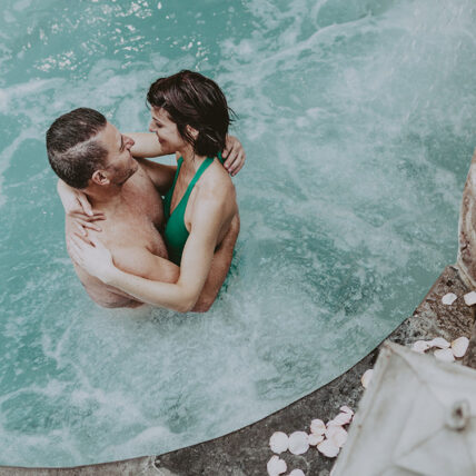 A couple enjoying the hot spring pool at 100 Fountain Spa, a spa near Queen's Landing.