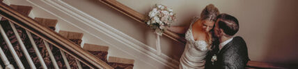 Newlyweds sharing a private moment on the staircase at the Queens Landing Hotel in Niagara-on-the-Lake