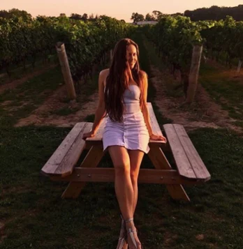 Woman sitting on a picnic table in a vineyard