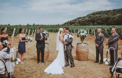 Newlyweds share passionate moment at Headlands Site vineyard wedding venue at Inn On The Twenty in Jordan Village