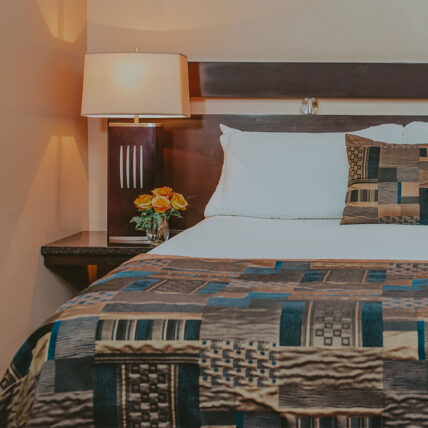 Queen size beds with stylish linens at Jordan House in Jordan Village