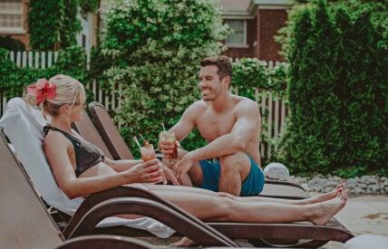 Couple relaxing on lounge chairs at the Poolside Patio at the Pillar & Post Hotel in Niagara-on-the-Lake