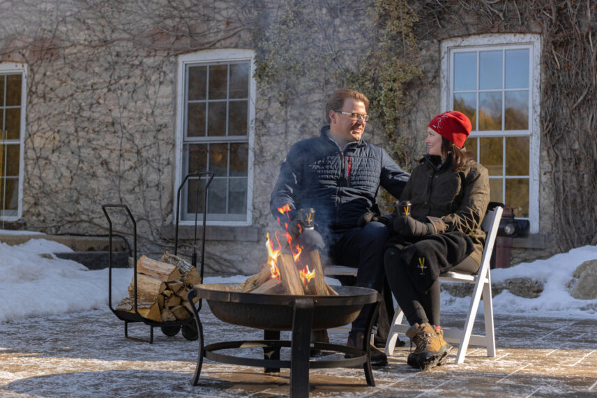 A couple sitting by a fire pit at Millcroft Inn & Spa in Caledon, Ontario.