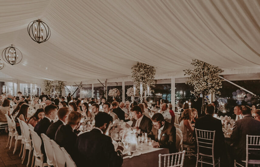 Guests seated around tables at a winery wedding hosted at Château des Charmes in Niagara-on-the-Lake.