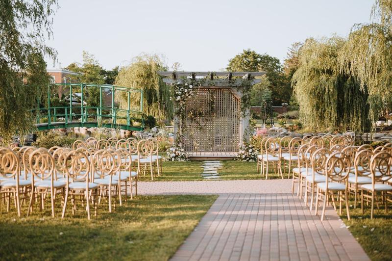 Chairs set up for a wedding ceremony in front of the Pont du Monet at Pillar and Post
