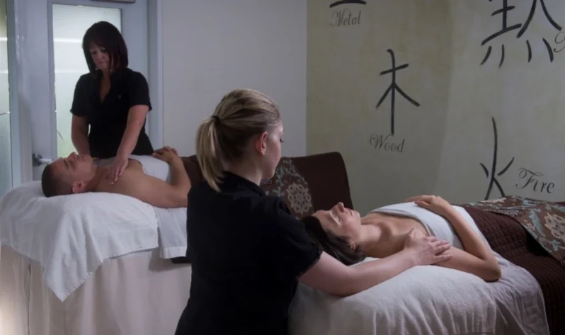Massage therapists providing a couples’ massage during a spa getaway