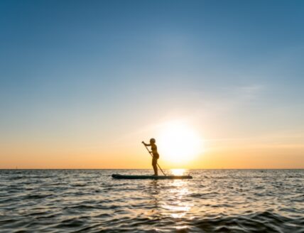 A person enjoying a stand-up paddleboard, and adventure activity in Niagara on the Lake