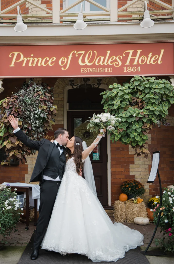 Bride and groom in front of the entrance to Prince of Wales