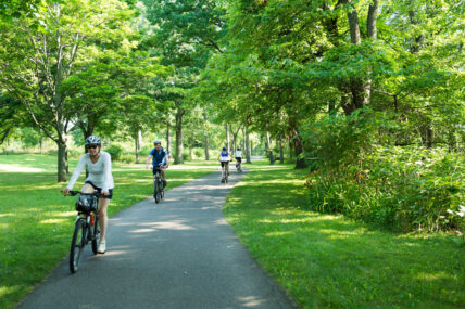 People riding Zoom Leisure Bikes through a park in Niagara on the Lake