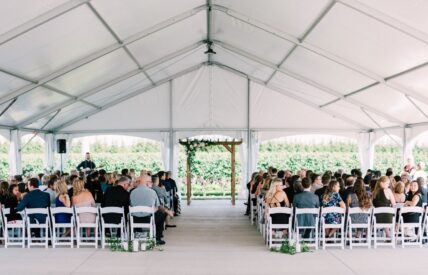 A wedding ceremony set up under the tented vineyard terrace at Bella Terra Vineyards