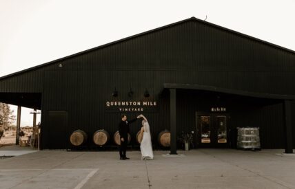 A newly married couples poses outside of Queenston Mile Vineyard winery in Niagara-on-the-Lake