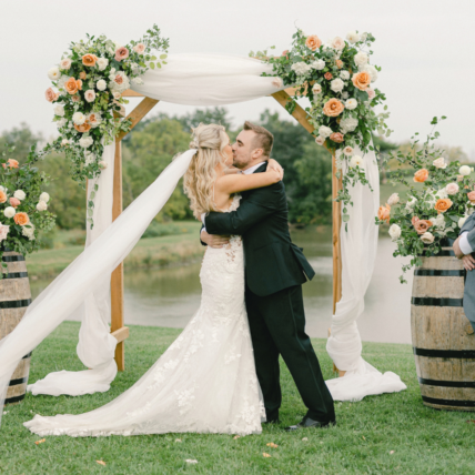A newly married couple kissing under the altar at Sue-Ann Staff Winery in Niagara-on-the-Lake.