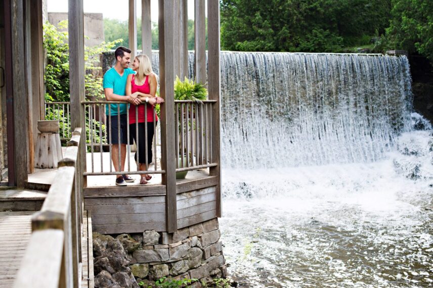 Couple walking near the waterfall at the Millcroft Inn & Spa during fall.