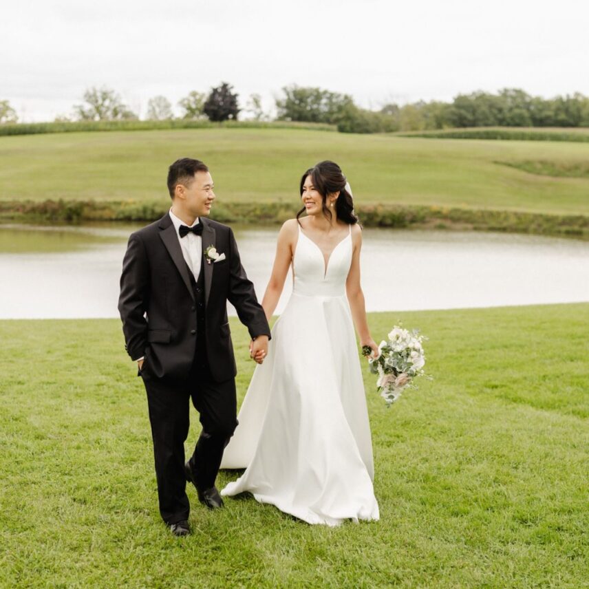 A couple walks across the lawn of their spring wedding at Sue-Ann Staff Estate Winery
