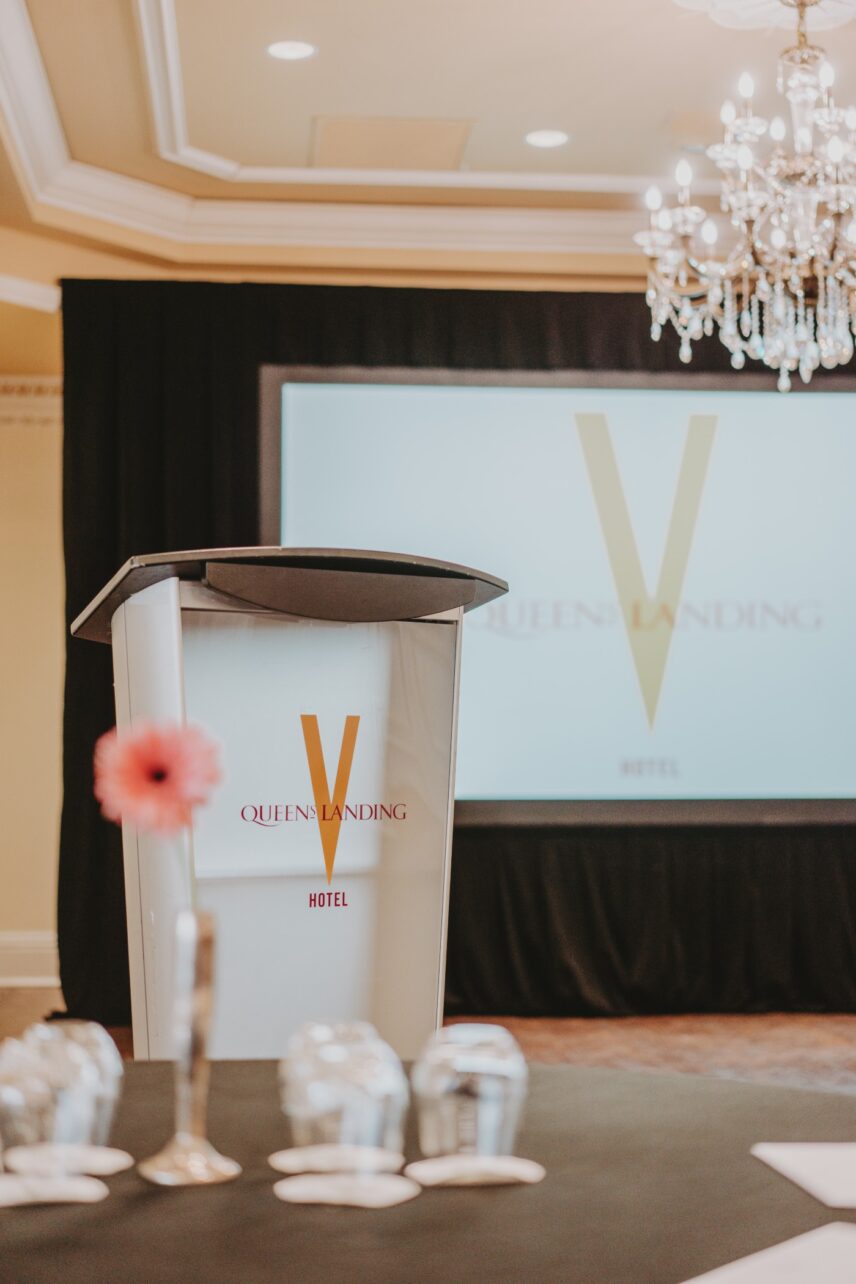 Meeting setup with podium and screen at Queen’s Landing Imperial Ballroom