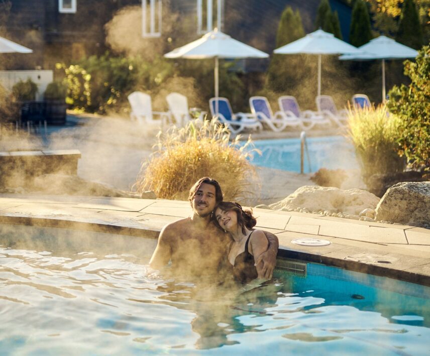 A couple relaxing in outdoor hot spring pools at Millcroft and Spa, near Caledon.